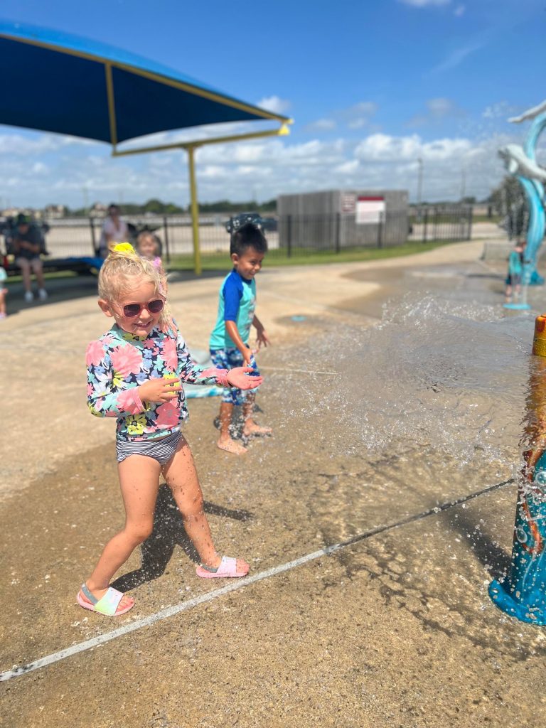 girl and boy play one of the Houston Area splash pads