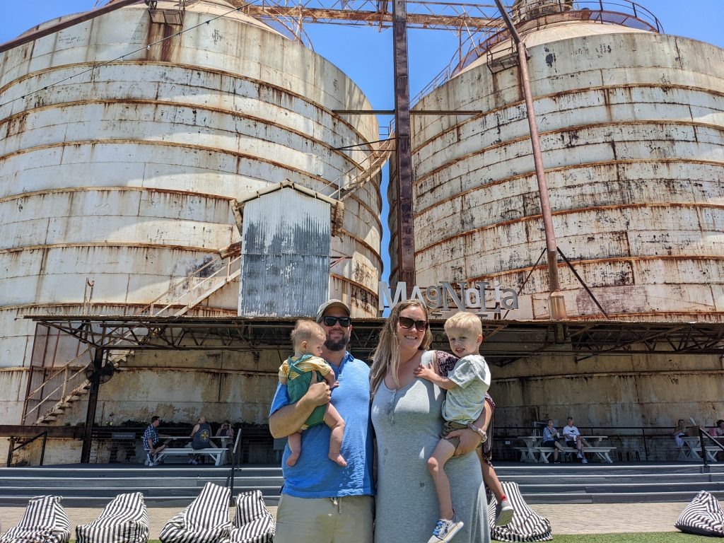 mom, dad and two boys stand in front of the Waco silos