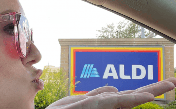 woman blows kiss in car next to ALDI sign