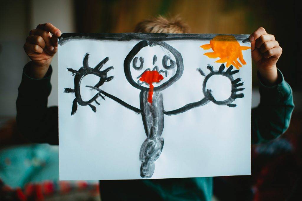 young child holding up painting 
