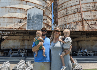 family of four in front of Waco silos