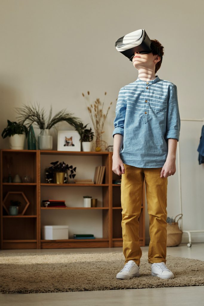 child stands wearing virtual reality goggles