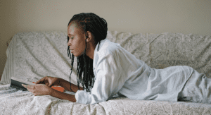 woman laying on bed reading book