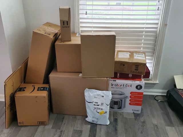 pile of Amazon boxes in corner of room