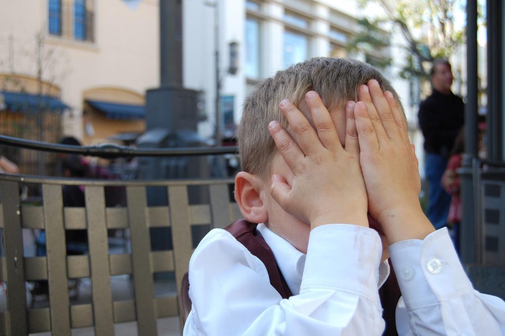 child covering face with hands