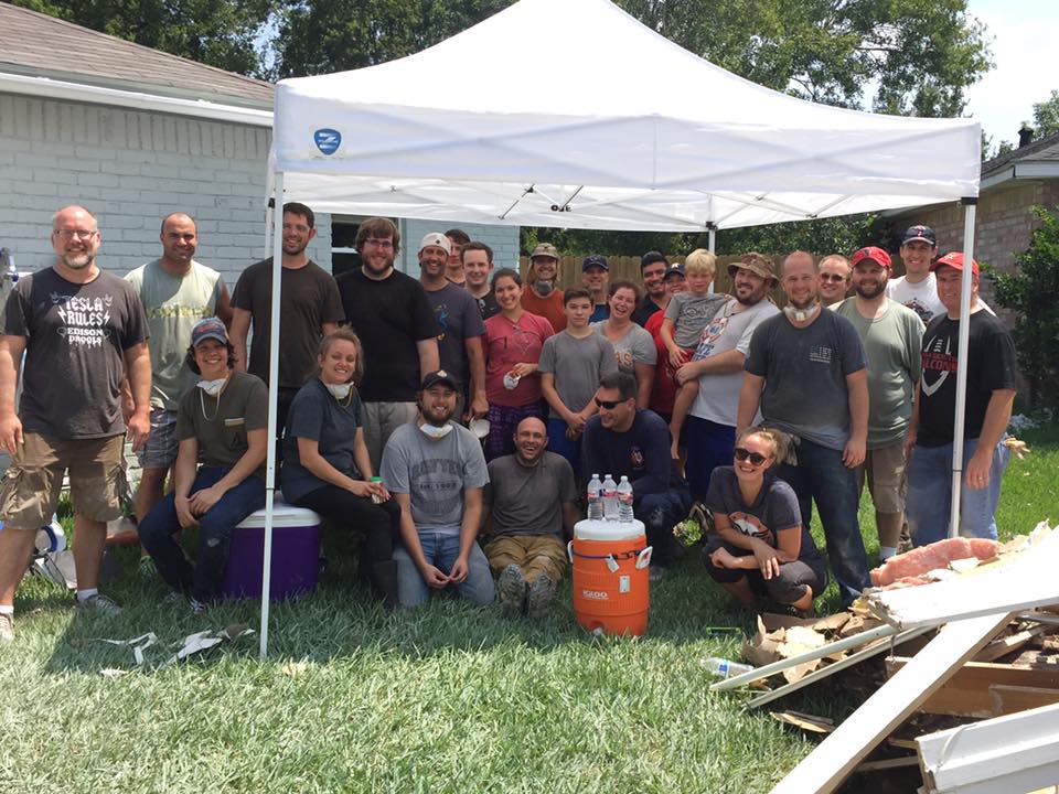 group of hurricane relief volunteers gather under tent 