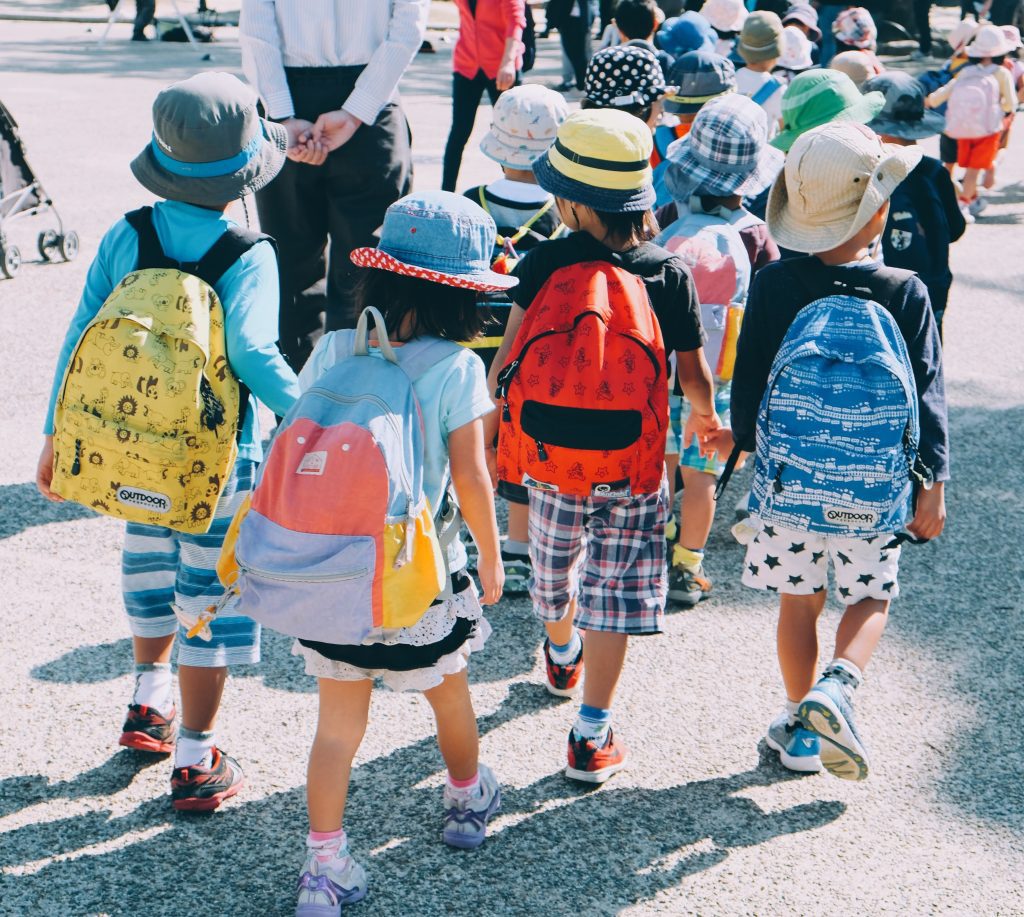 group of pre k students with backpacks walk in group