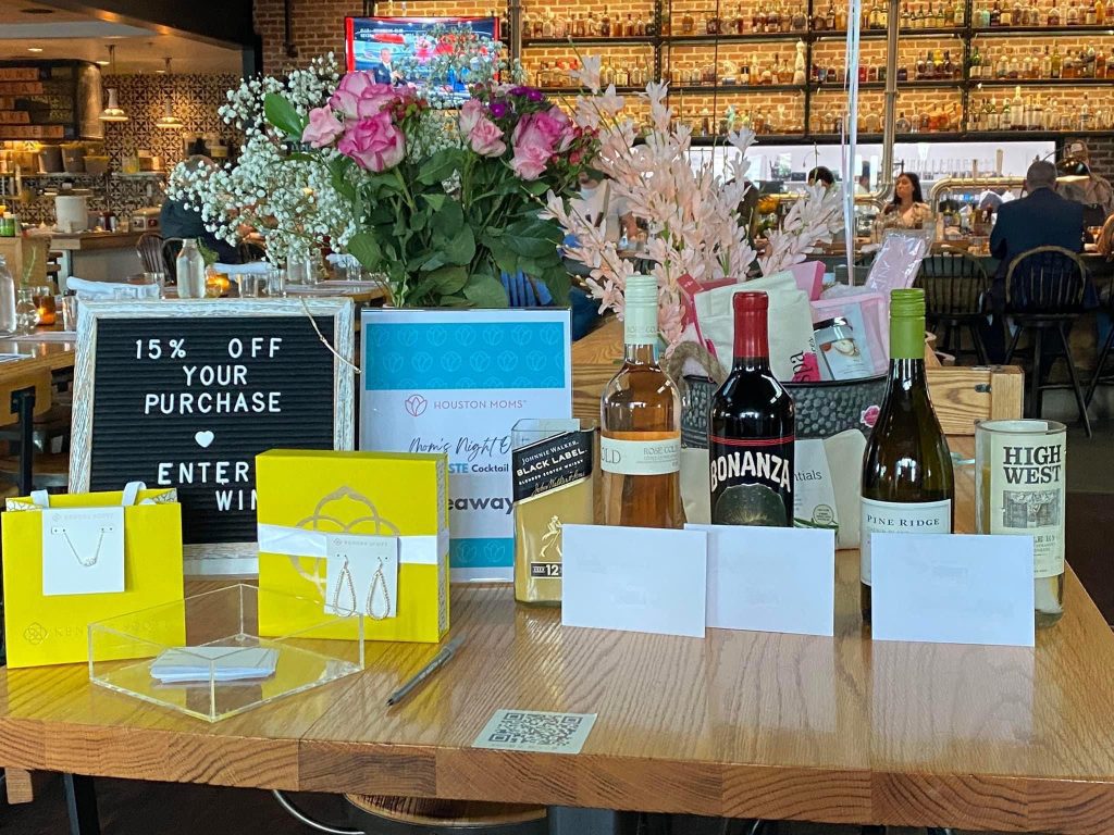 giveaway table of jewelry, wine, and other gift box