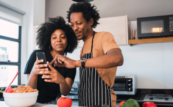 couple in kitchen looking at phone