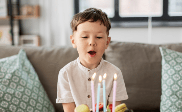 young boy blowing out birthday candles