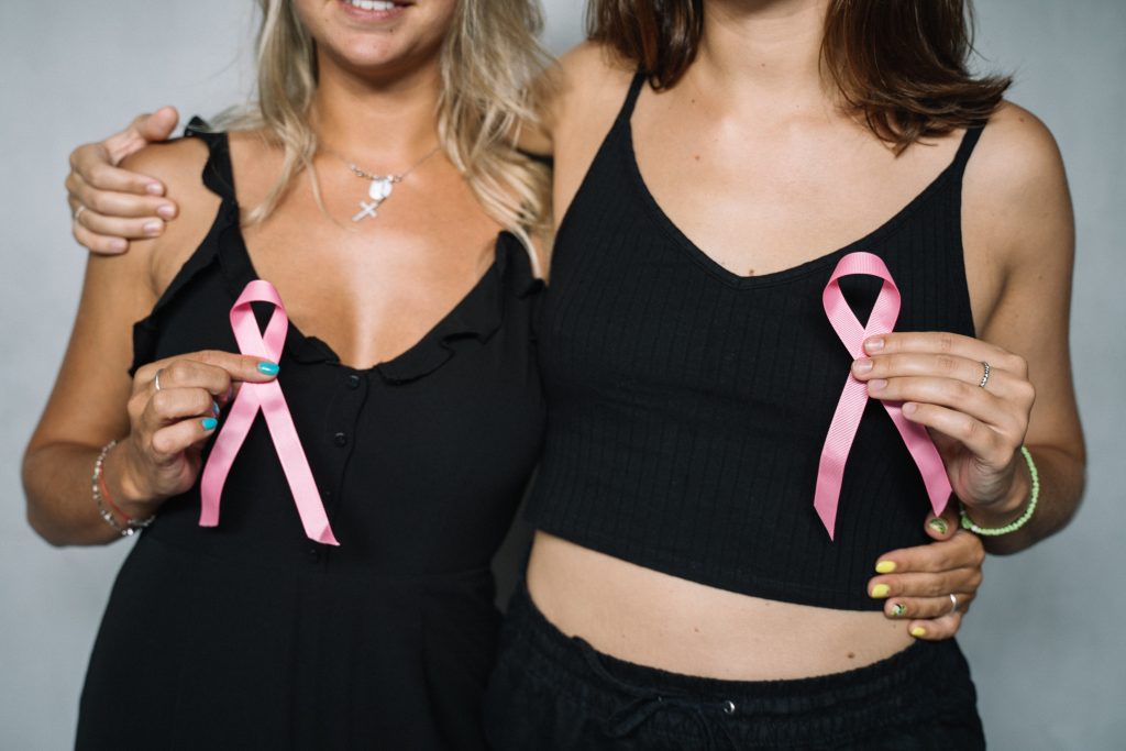 women in black hold up pink ribbons