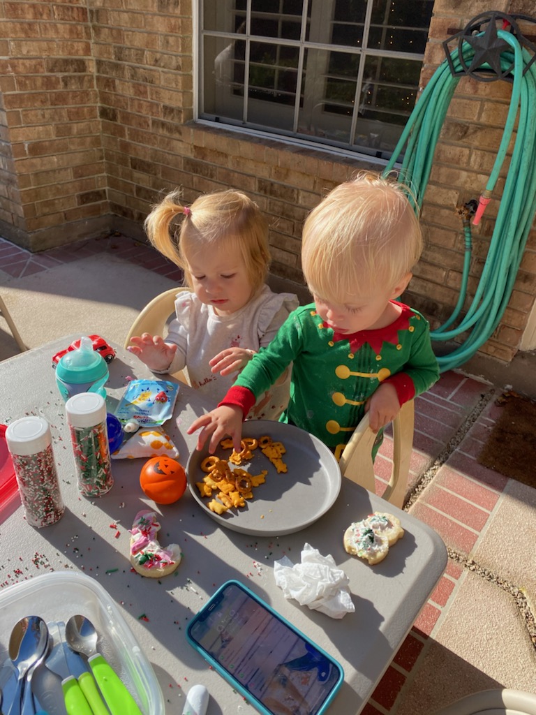 toddlers at an outside table eating snacks