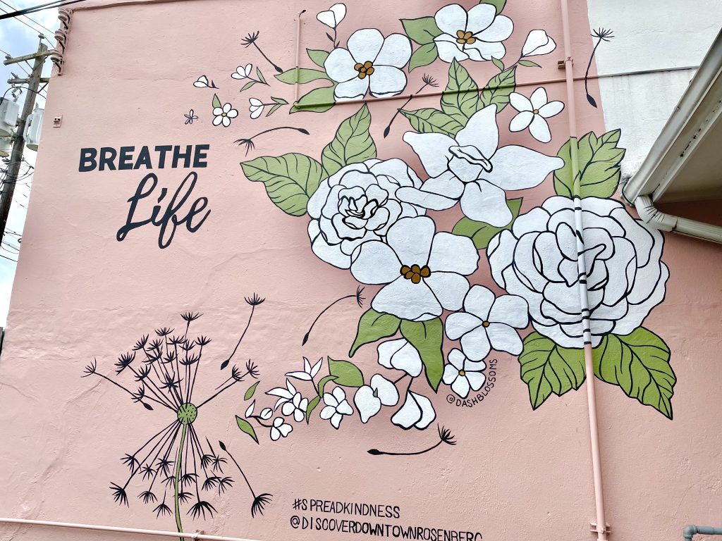 mural of white flowers that says "Breathe Life"