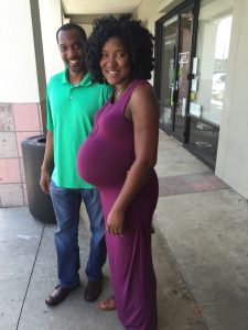 woman pregnant with twins stands with husband