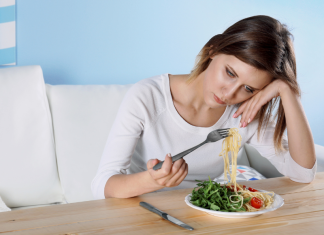 sad woman holding up a bite of spaghetti