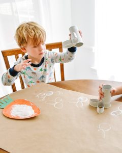 little boy stamping with toilet paper roll