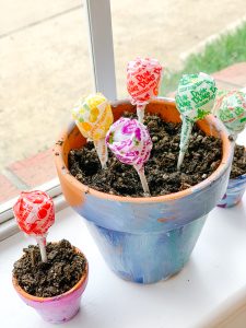 colorful pot of soil with lollipops sticking out of it