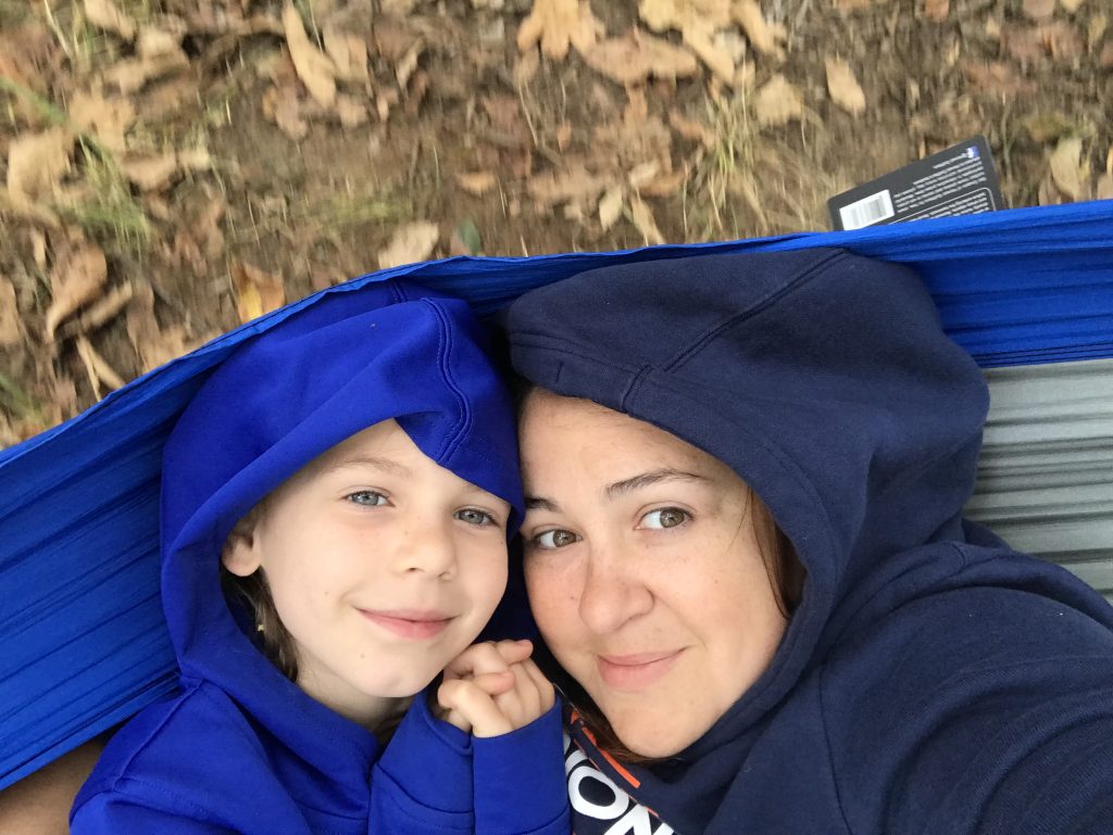 mother and daughter cuddle on campground