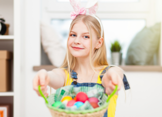 teen with bunny ears holding easter basket filled with eggs