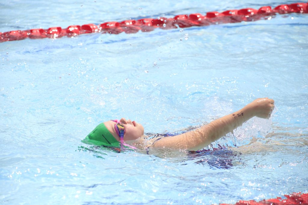 girl doing backstroke in pool