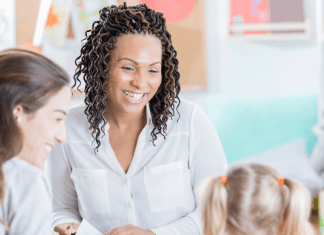 teacher smiling at girl and her mother