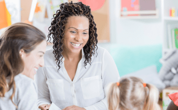 teacher smiling at girl and her mother