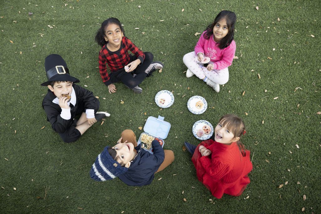gifted children sit in circle on grass