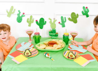 Two little boy preschoolers sitting at a table decorated for Cinco de Mayo
