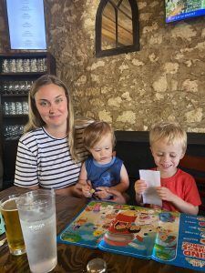 mother sits with two young children at restaurant