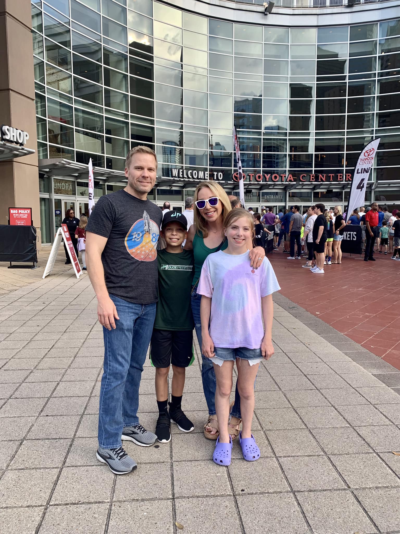 mom and dad in front of the Toyota Center with two kids
