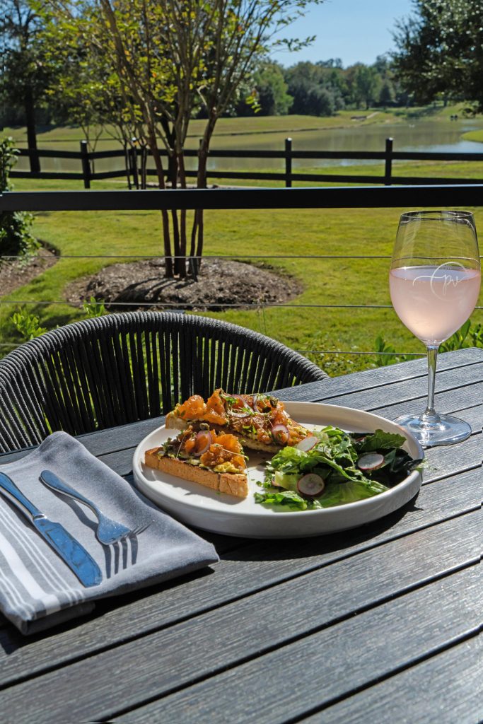 plate of food and glass of wine on outdoor table