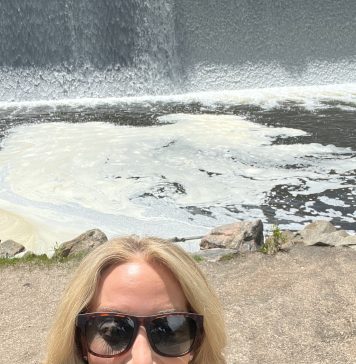 Woman standing outside of a natural waterfall in Colorado