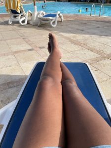 woman's legs stretched out on a beach chair