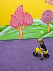 child on tricycle in indoor playground