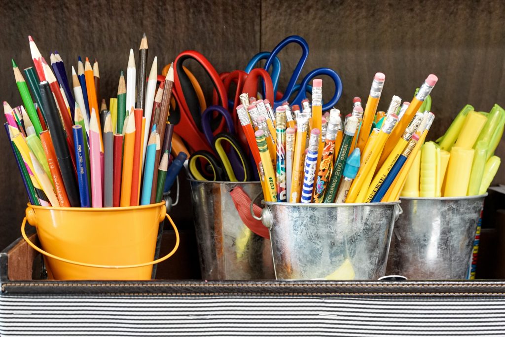 buckets full of pencils, colored pencils, and scissors