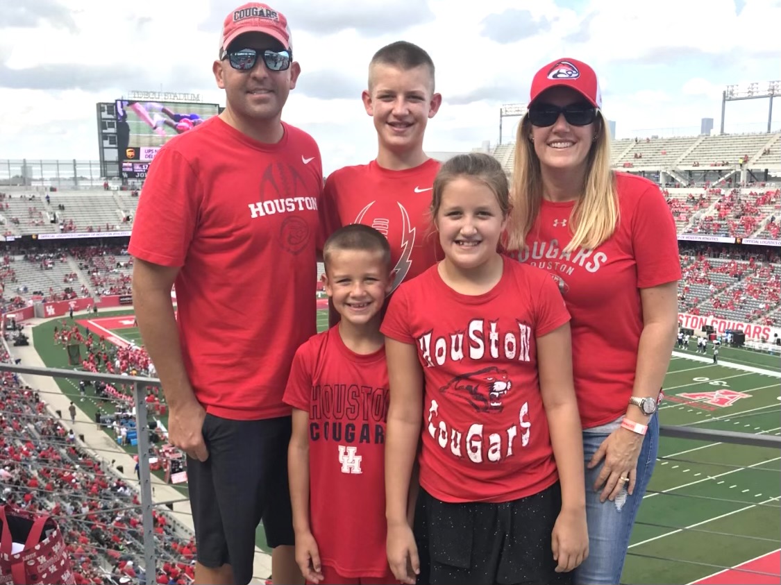 family in Houston Cougars shirts in football stadium