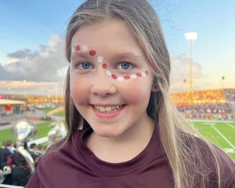 young girl at football game with painted face