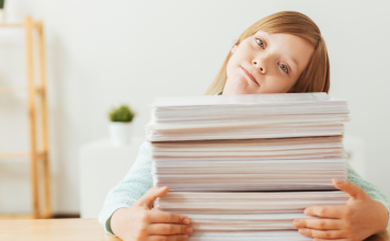 girl with pile of school papers