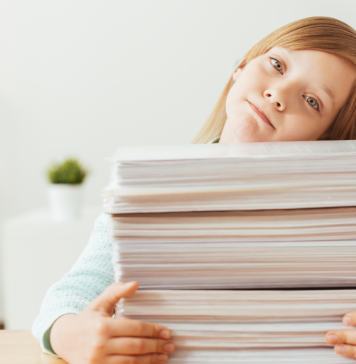 girl with pile of school papers