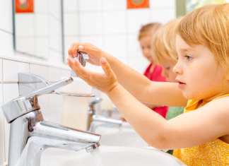 child washing hands at sink