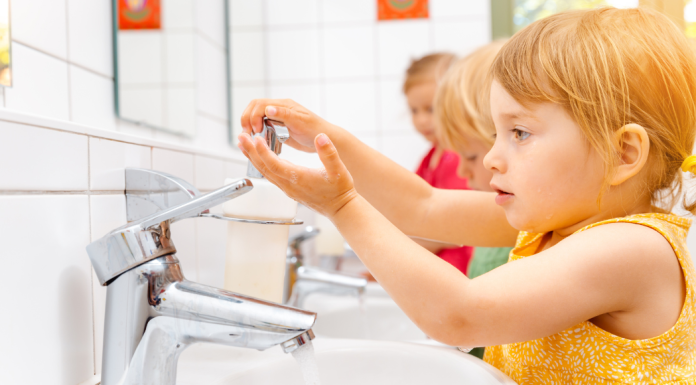 child washing hands at sink