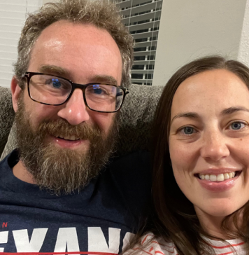 couple sits on couch for date night in
