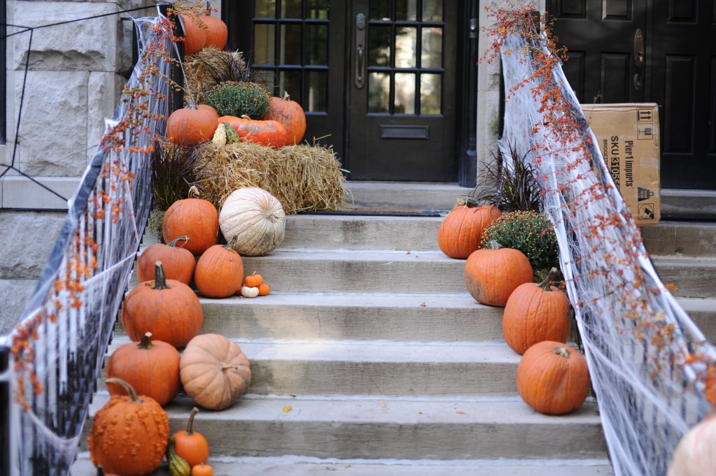 steps leading up to front door decorated with pumpkins