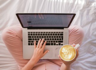 Woman in her pajamas drinking coffee and shopping online