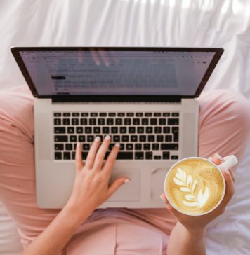 Woman in her pajamas drinking coffee and shopping online