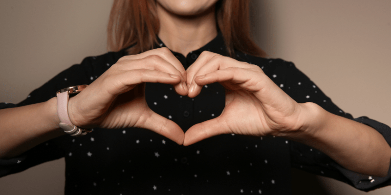 woman doing heart sign with her hands