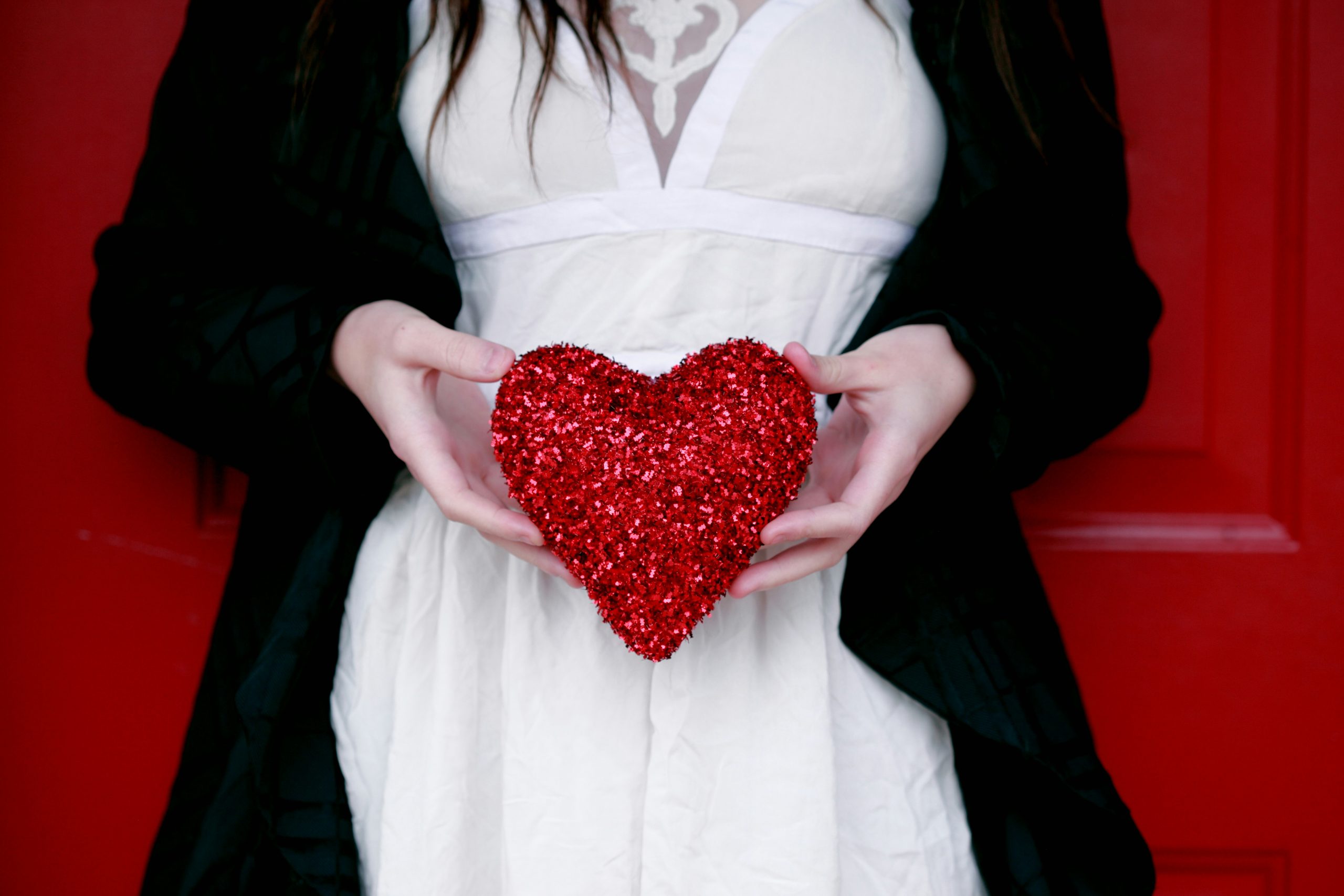 A woman holding a sparkling red heart