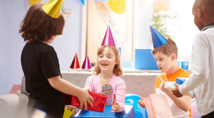 children giving girl a birthday gift