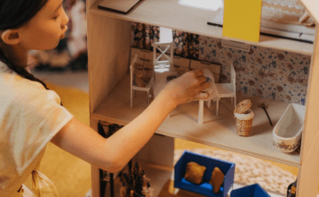 girl playing with dollhouse