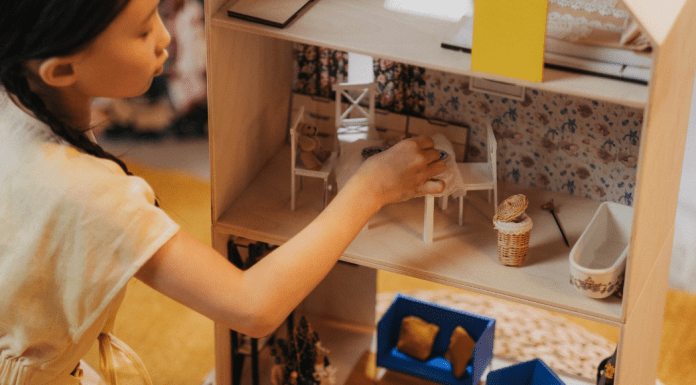 girl playing with dollhouse